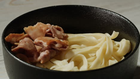 bowl of noodles with egg and pork