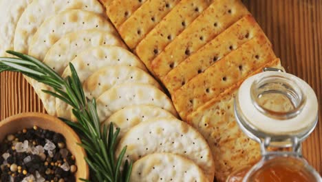 bowl of green olives, spices, crispy biscuits, jam, rosemary herb, cheese and walnuts