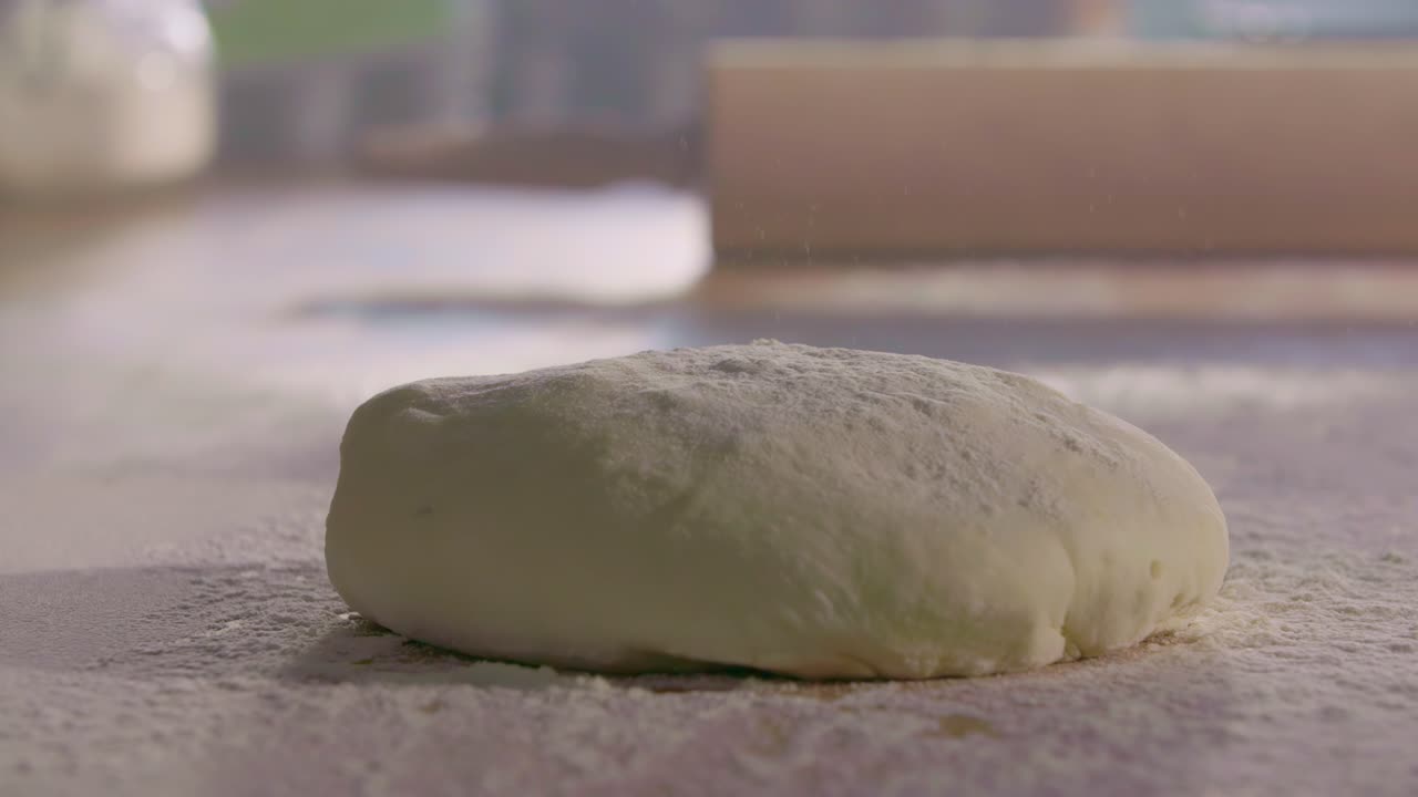 Dough Dropping onto Flour-Covered Kitchen Surface