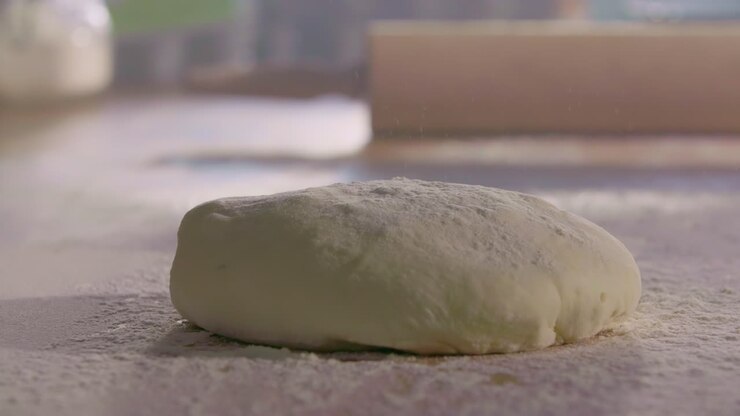 Dough Dropping onto Flour-Covered Kitchen Surface
