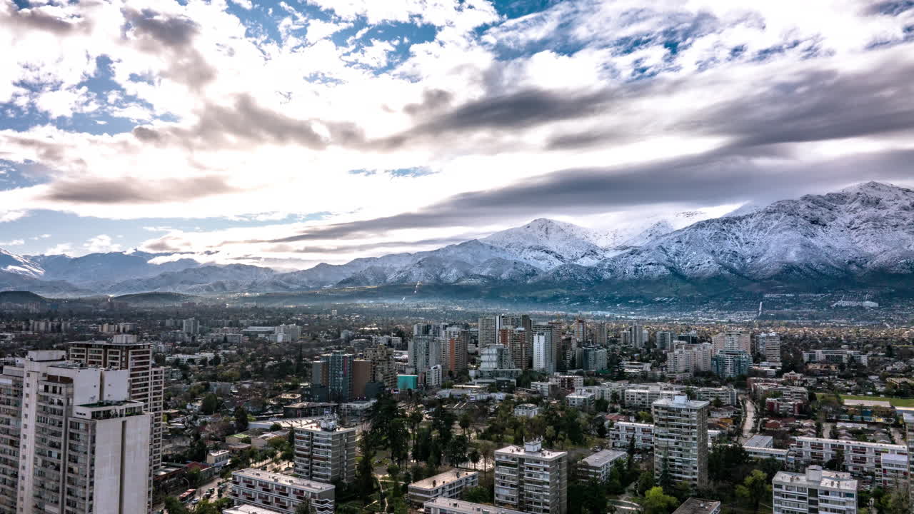 Hyperlapse aereo con panoramica a sinistra su Santiago del Cile, con ombre di nuvole in rapido movimento che creano motivi di luce dinamici sulla città