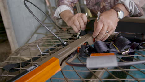 man working on assembling a tree stand for hunting