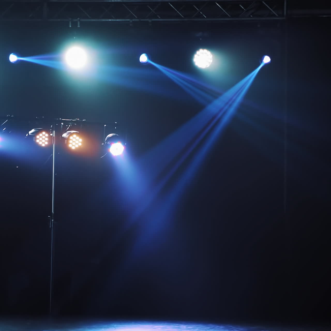 Beautiful view of flashing lights with different colors lightning from spotlights. Bright colors of projectors shining from top on the stage in the nightclub.