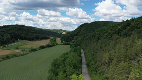 Aerial-view-of-car-driving-down-country-road-at-the-sunny-day