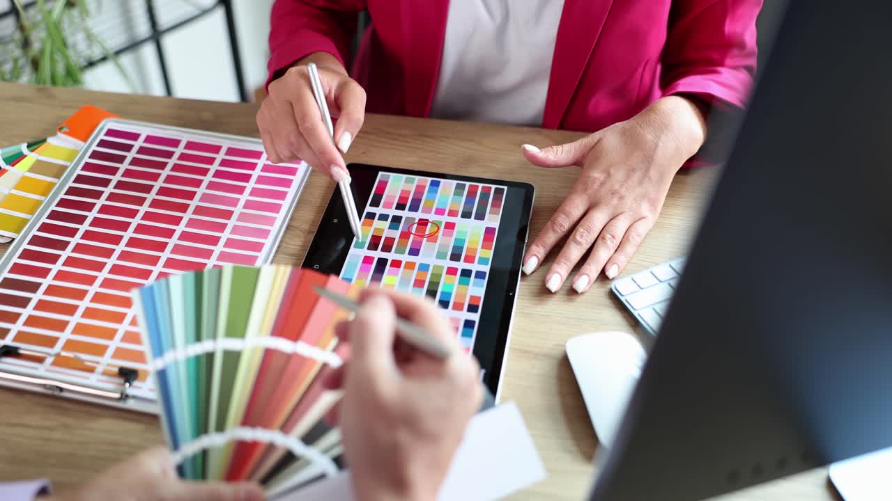 Interior designer lavorano in team con campioni colore su una scrivania d'ufficio