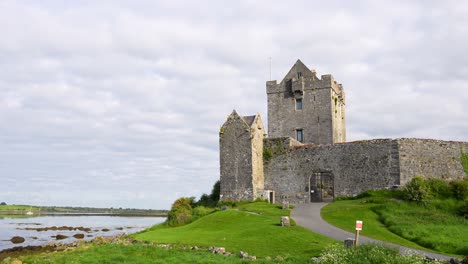 Left-pan-from-sign-towards-historic-Dunguaire-Castle-in-Kinvarra,-Ireland