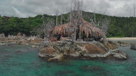 panoramic aerial view of restaurant on the stony cliff among the coral bay on tropical island