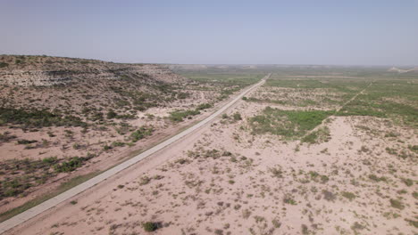 a rural road in the west texas desert with distant 18 wheelers