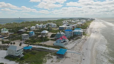 Drone-Pan-De-Hermosa-Playa-De-Arena-Blanca-En-Cabo-San-Blas,-Florida-Con-Coloridos-Condominios