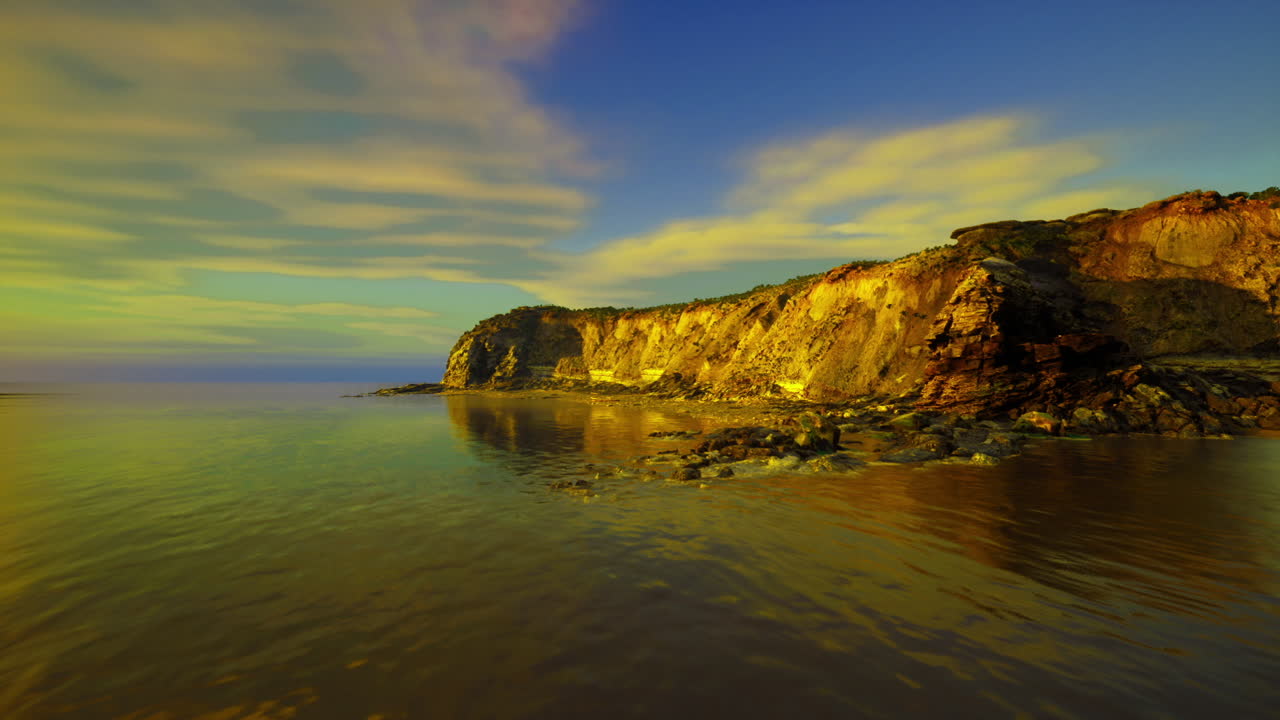 Magnífico paisaje costero con olas suaves y vivos colores del atardecer