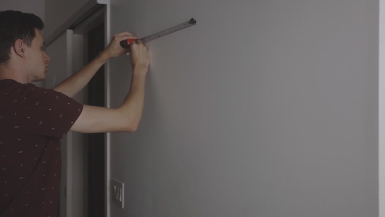 테이프 측정으로 벽을 측정하고 연필으로 벽을 표시 - 중간  ⁇