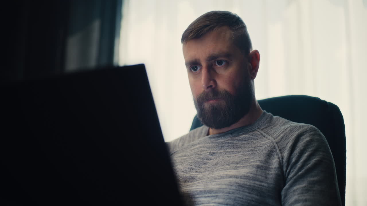 Focused Professional Stock Exchange Broker Monitoring Real-Time Stocks and Exchange Market Charts Using Laptop Computer, Making Investments. Successful Investment Agent Working in Modern Home Office.