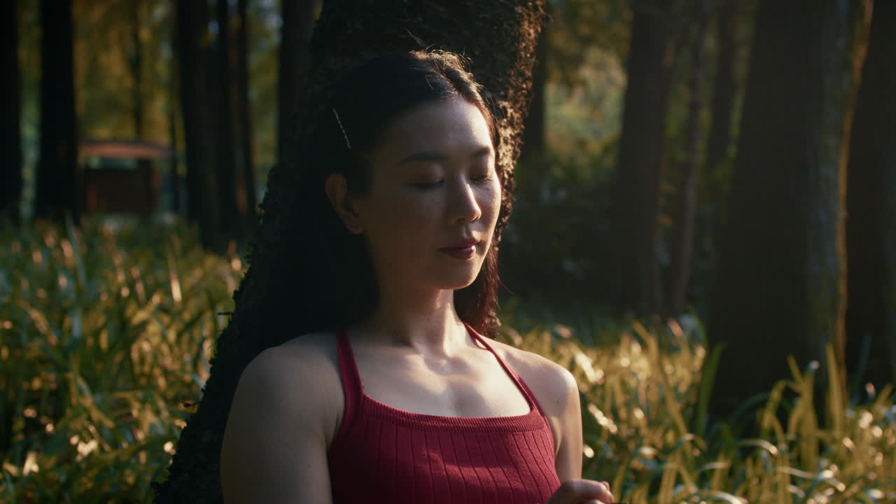 Woman meditating and journaling in a park at sunset
