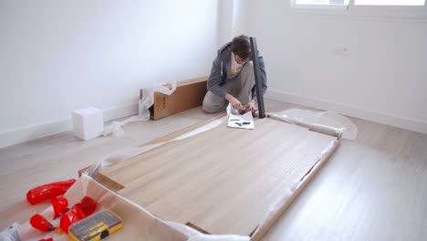 White-man-reading-manual-and-assembling-diy-table-set