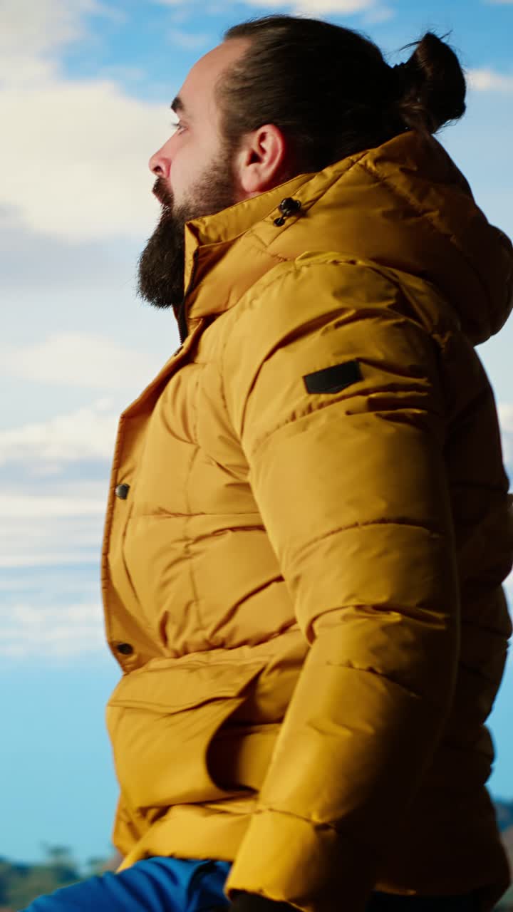 Man in Yellow Puffer Jacket Standing Up and Looking at Mountain View