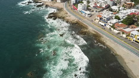 green and blue waves hitting a rocky and sandy beach city, mazatlan