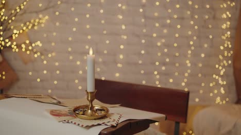 candle on a desk with holiday decor and bokeh lights, creating a warm christmas scene