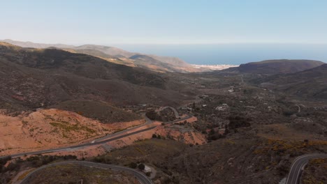 The-mountains-near-Almeria-in-the-south-of-Spain-with-in-the-background-the-greenhouses,-Aerial-shot