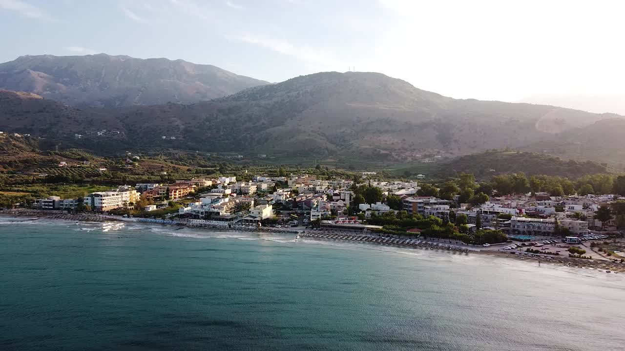 Beautiful mountains and small Cretan township during sunset, aerial view