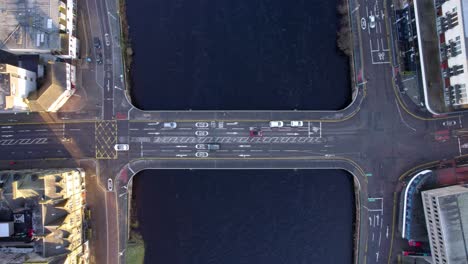 vehículos que cruzan un puente en invierno sobre el río, destacando el flujo urbano y el paisaje