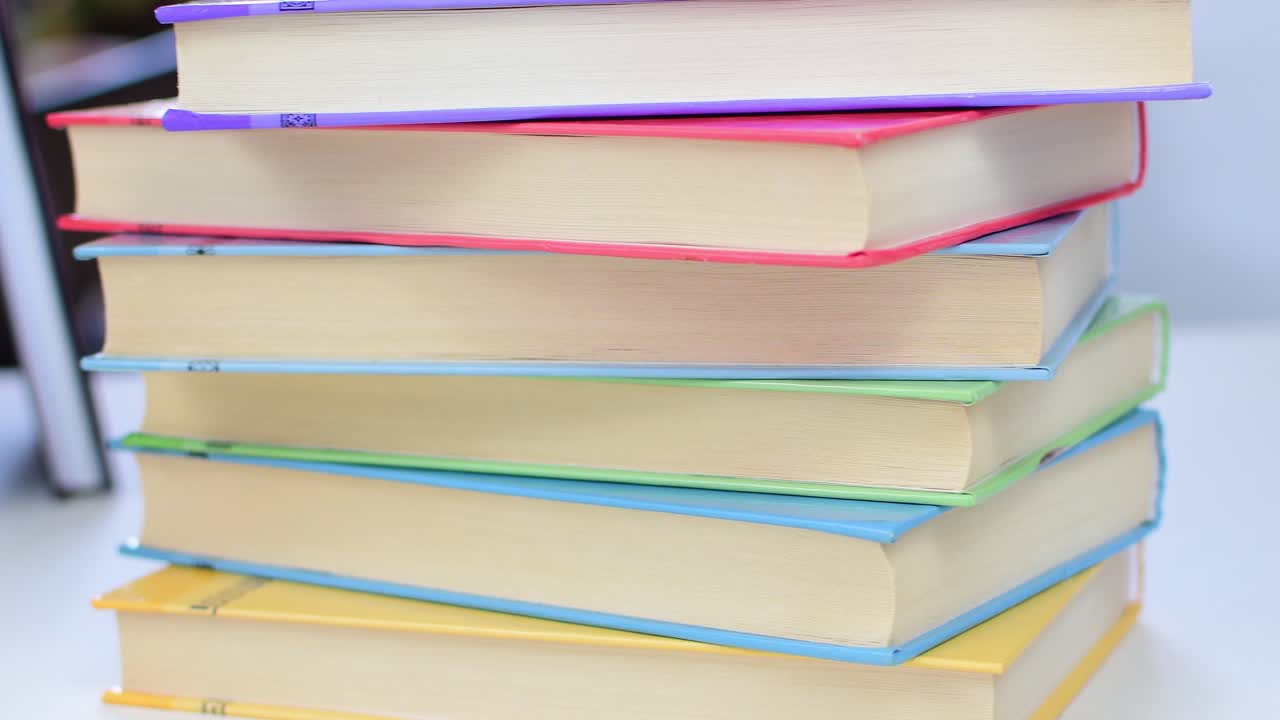Desk with stack of study books. Textbooks for the student, university. Study from home. Distance education concept.