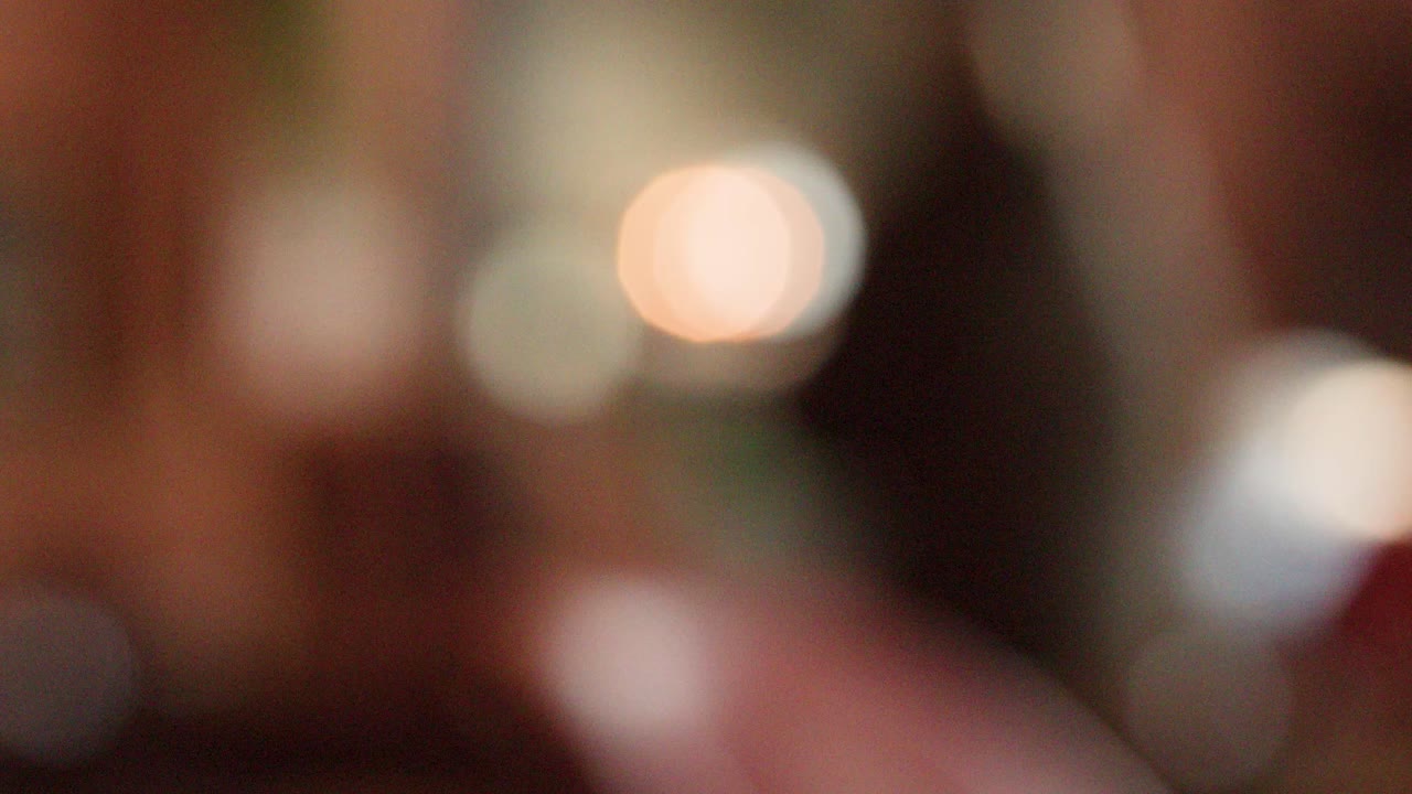 Soft bokeh effect, blurred figures and objects, warm indoor lighting, subtle camera movement throughout