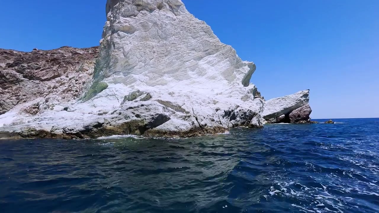Plavba kolem sopečných skal Bílé pláže na Santorini v Řecku.