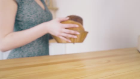 la chica quita panes de la mesa en la cocina