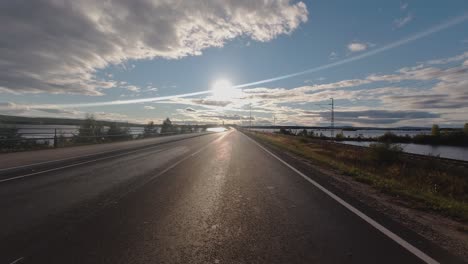 Conducir-Hacia-El-Sol-Punto-De-Vista:-Agua-A-Ambos-Lados-De-La-Carretera-Y-La-Vía-Férrea