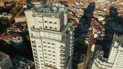 Vista-De-ángulo-Alto-De-La-Parte-Superior-Del-Antiguo-Rascacielos,-Torre-De-Madrid.-Incline-Hacia-Arriba-La-Revelación-Del-Paisaje-Urbano.