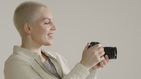 side view of a young woman using a dslr camera