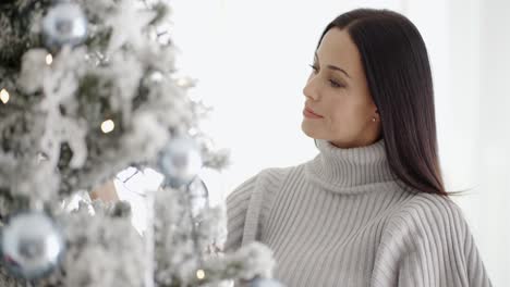 una joven bonita decorando su árbol de navidad.