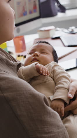a mother holds her sleeping baby