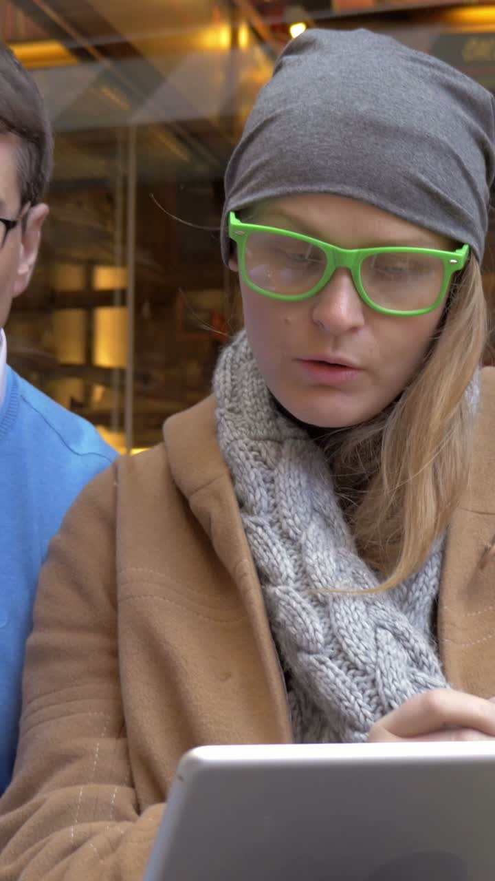 People drinking coffee and using a tablet