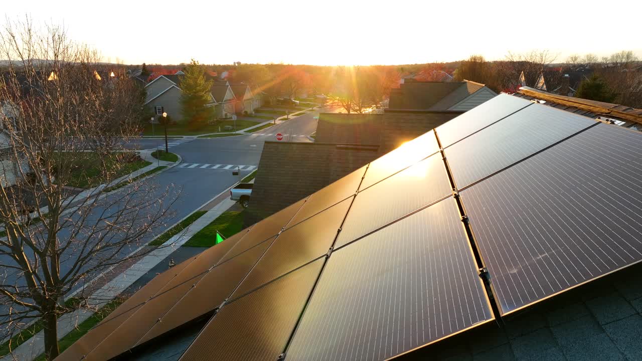 vista aérea de un vecindario suburbano durante la puesta de sol, destacando paneles solares en un techo, capturando la belleza y la sostenibilidad de la zona en los estados unidos
