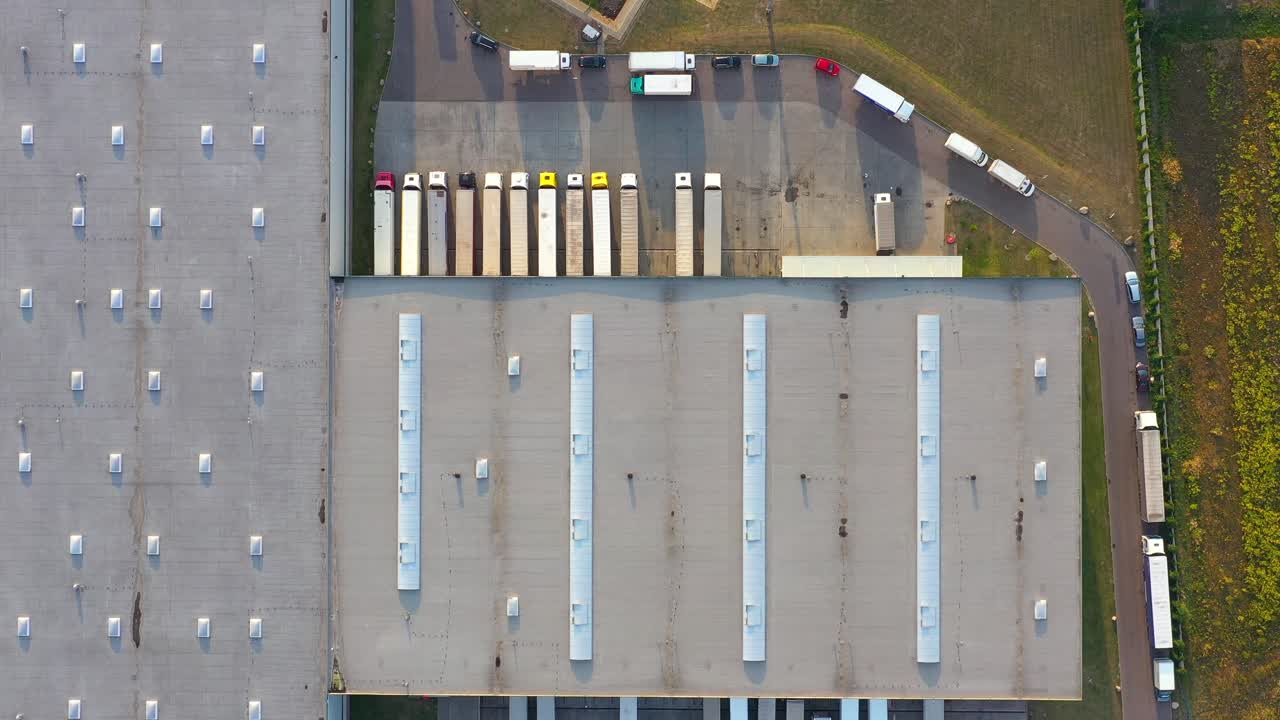 semirremolque con remolque de carga viaja a lo largo de un estacionamiento de un almacén en el parque logístico