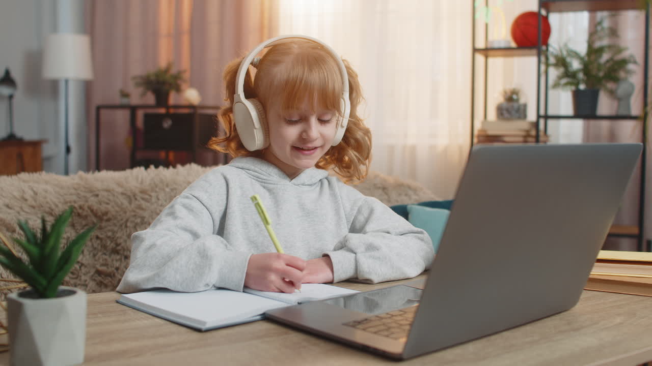 Young girl wearing wireless headphones learning english with audio lesson repeating new words aloud