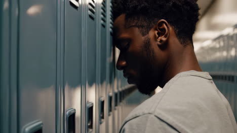 teenager leaning on lockers in school hallway