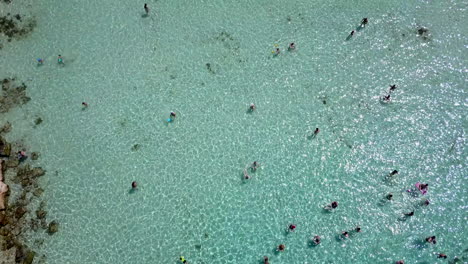 Luftaufnahmen-Von-Menschen,-Die-An-Einem-Flachen-Sandstrand-Baden