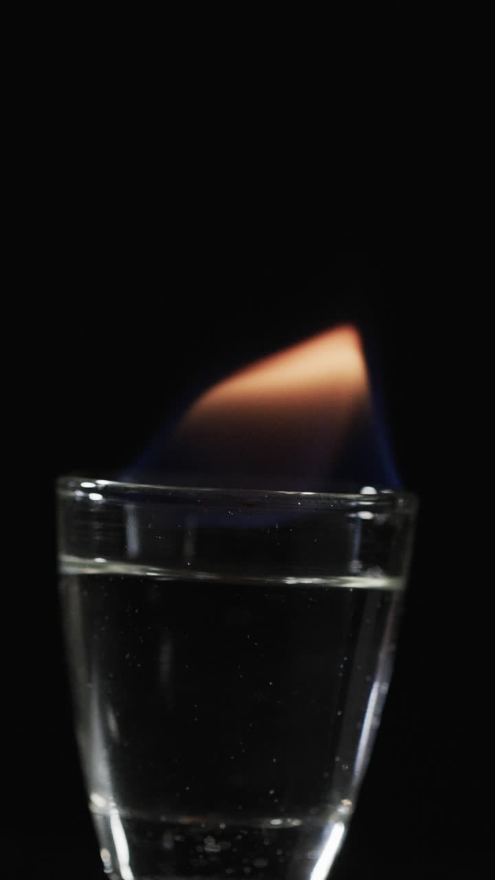 Vertical video of lit alcohol flames and copy space on black background