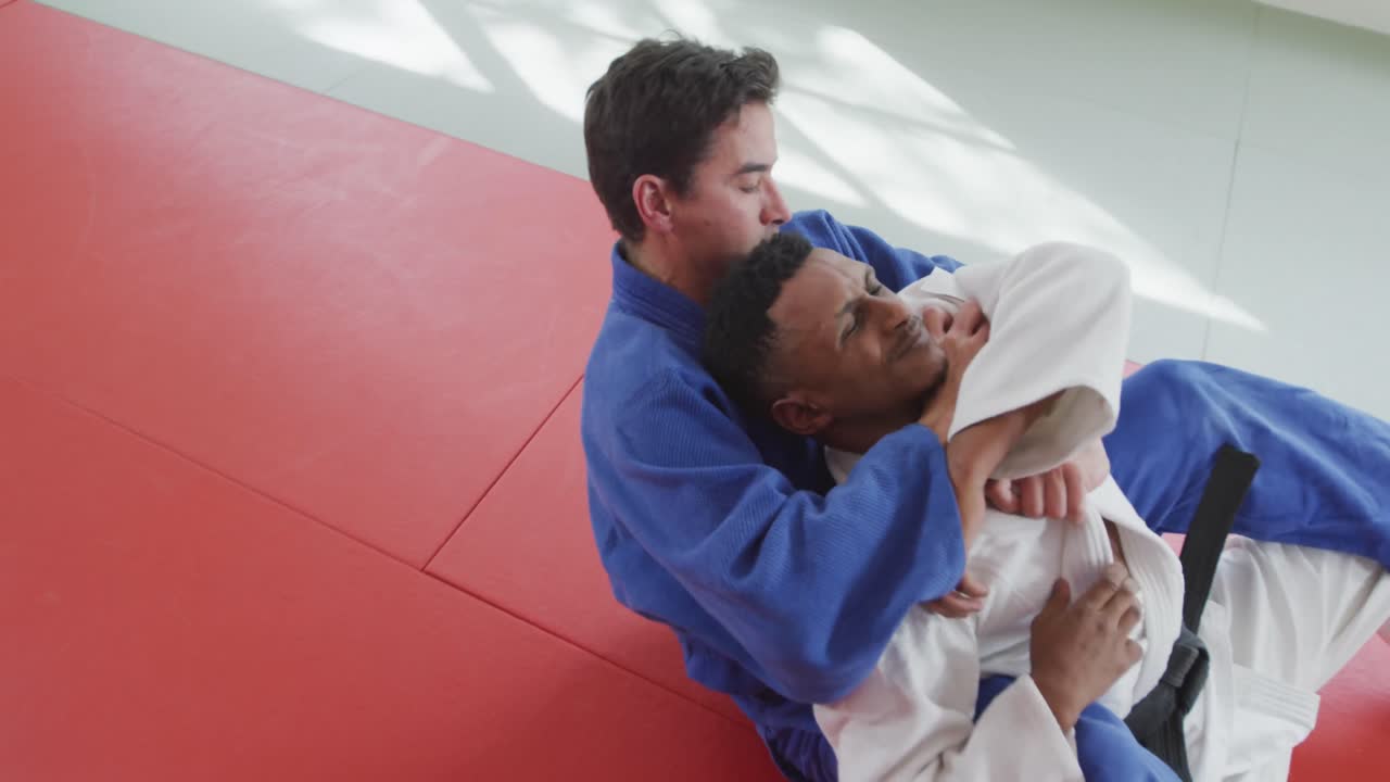 Judoka strangling his opponent on the judo mat