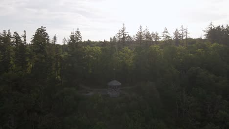 Aufsteigende-Luftaufnahme,-Die-Einen-Kleinen-Wachturm-An-Der-Seite-Des-Berges-Zeigt