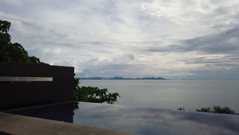 asian man working on the laptop by the pool - side view