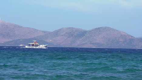 Slow-motion-of-a-fishboat-set-on-at-aegean-sea,-with-Evia-island-on-there-background
