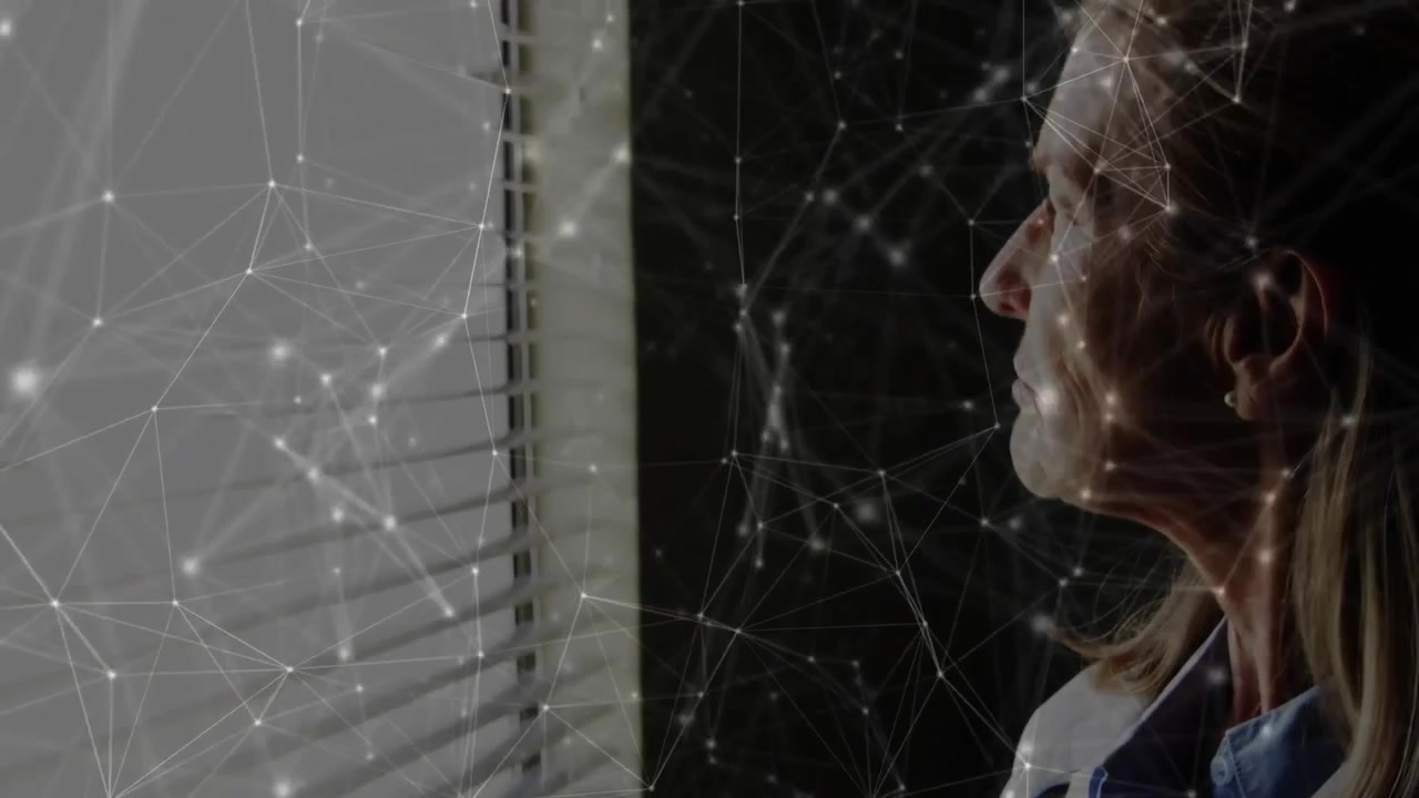 Female scientist analyzing technology, gazing beside window blinds with glowing network lines