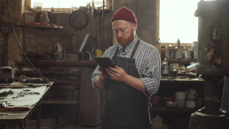 Blacksmith-Using-Digital-Tablet-in-Workshop