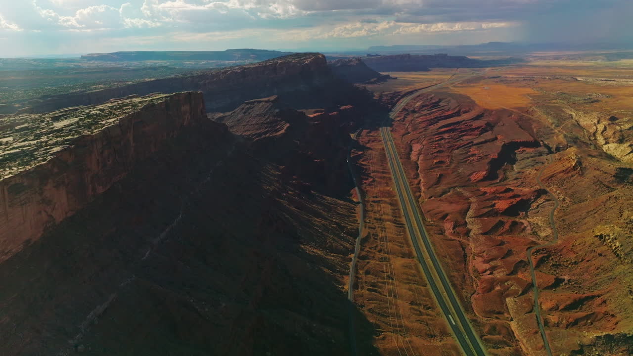 Flying above the motorways at the foot of fascinating canyons. Spectacular view of rocky relief from aerial perspective.