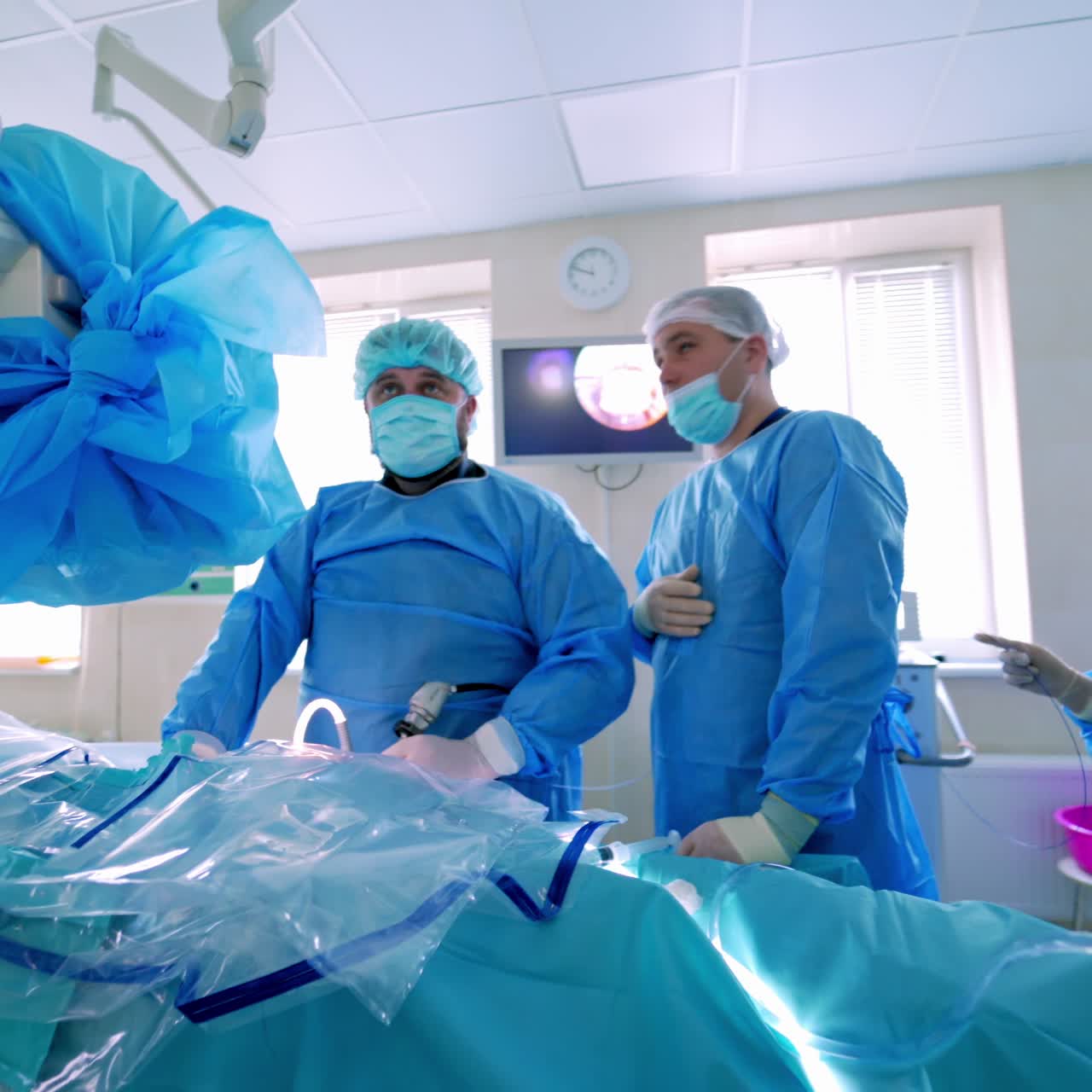 Operating room with surgery in progress. Medical team performing surgical operation in bright modern operating room