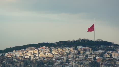 turkish flag on a hill overlooking istanbul cityscape in winter