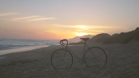 bicicleta estacionada na praia, bela paisagem por do sol